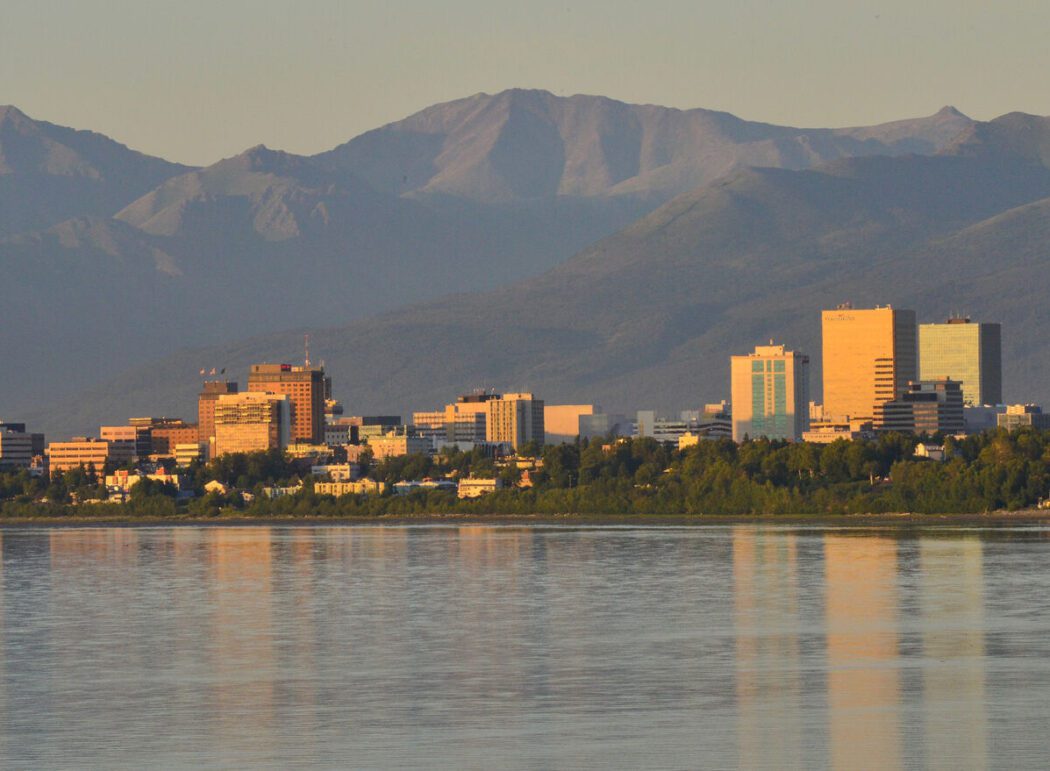 the city skyline of Anchorage, Alaska between mountains and water