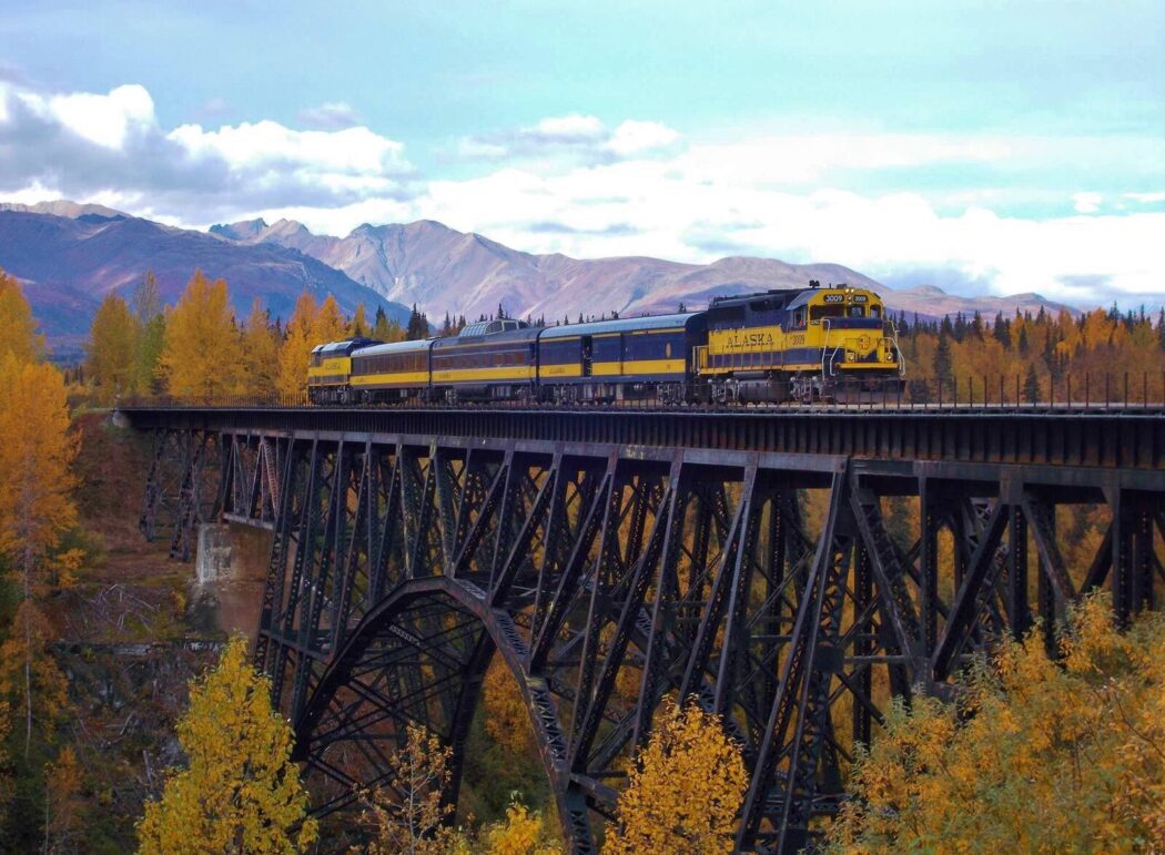 the 'Alaska' passenger train travels over an arch bridge over Hurricane Gulch
