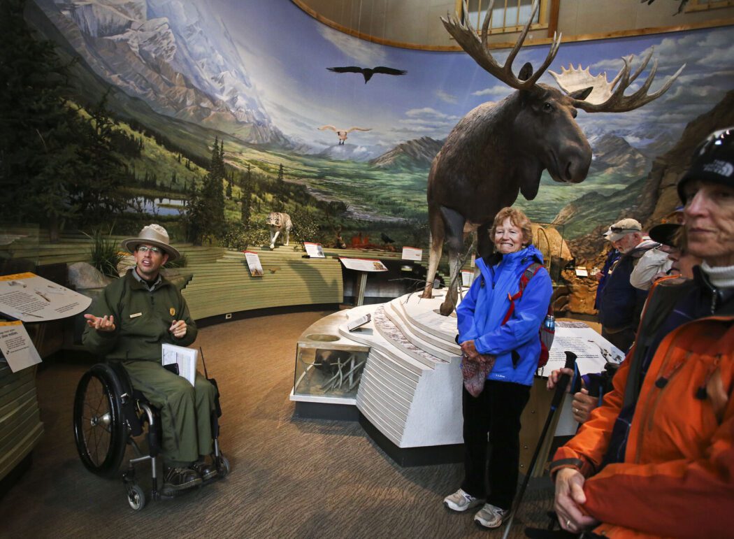 a park ranger speaks to a group of visitors inside the Denali National Park Visitors Center