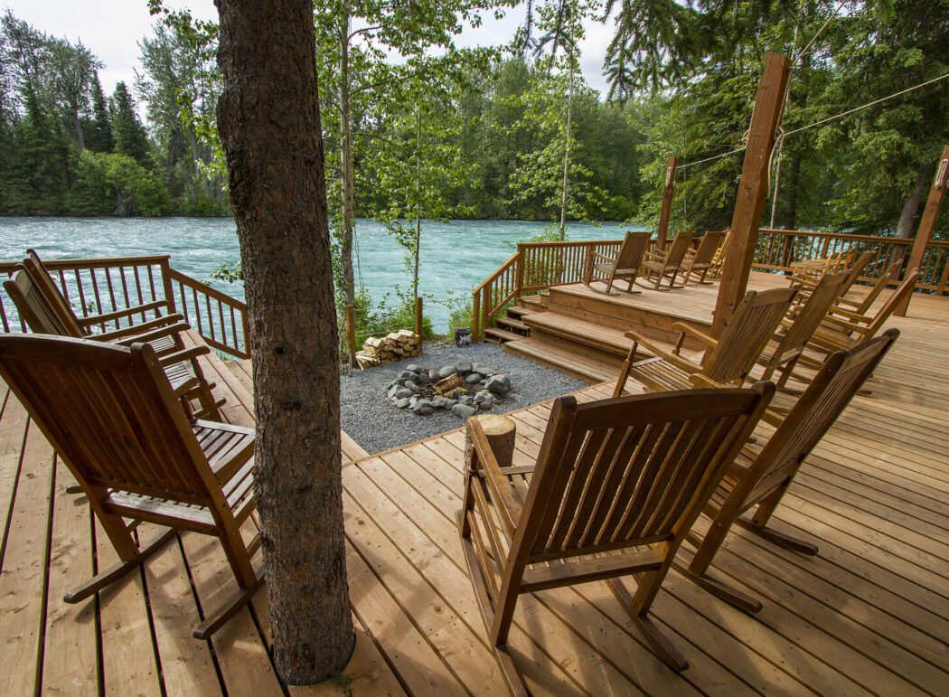 several wooden rocking chairs on a wooden deck overlooking the Kenai River in Alaska