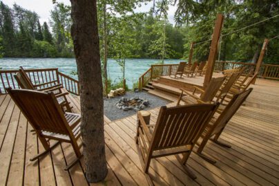 several wooden rocking chairs on a wooden deck overlooking the Kenai River in Alaska