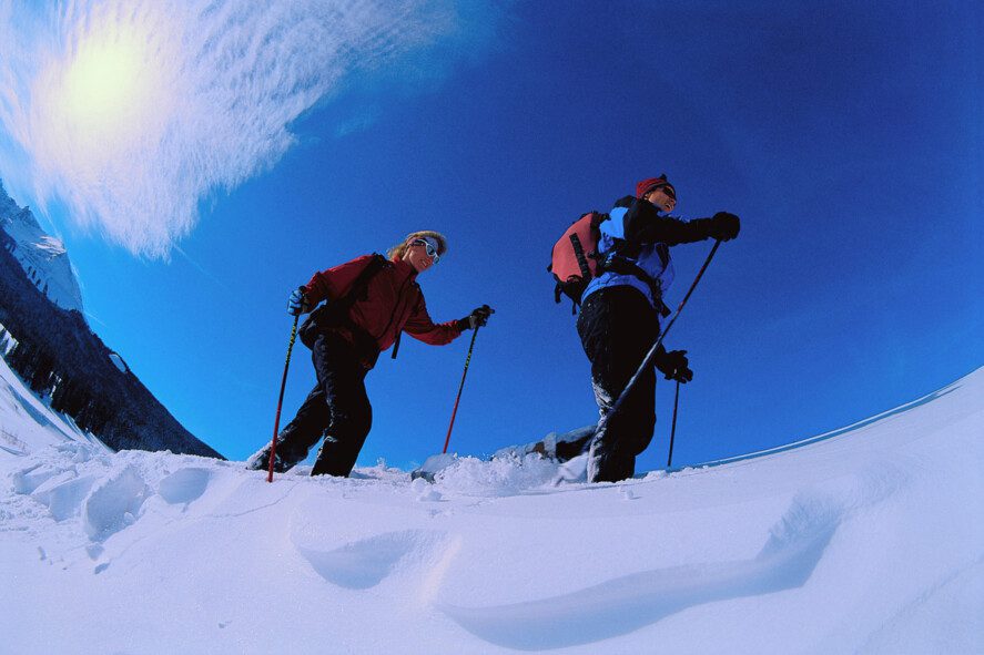 Couple Snowshoeing Across Landscape ca. 2000