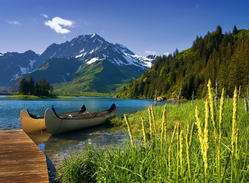 two canoes near a dock in Pederson Lagoon; mountains in background