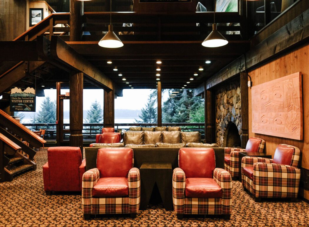 chairs, couches, a fireplace and Alaska Native artwork in the lobby of a lodge in Alaska
