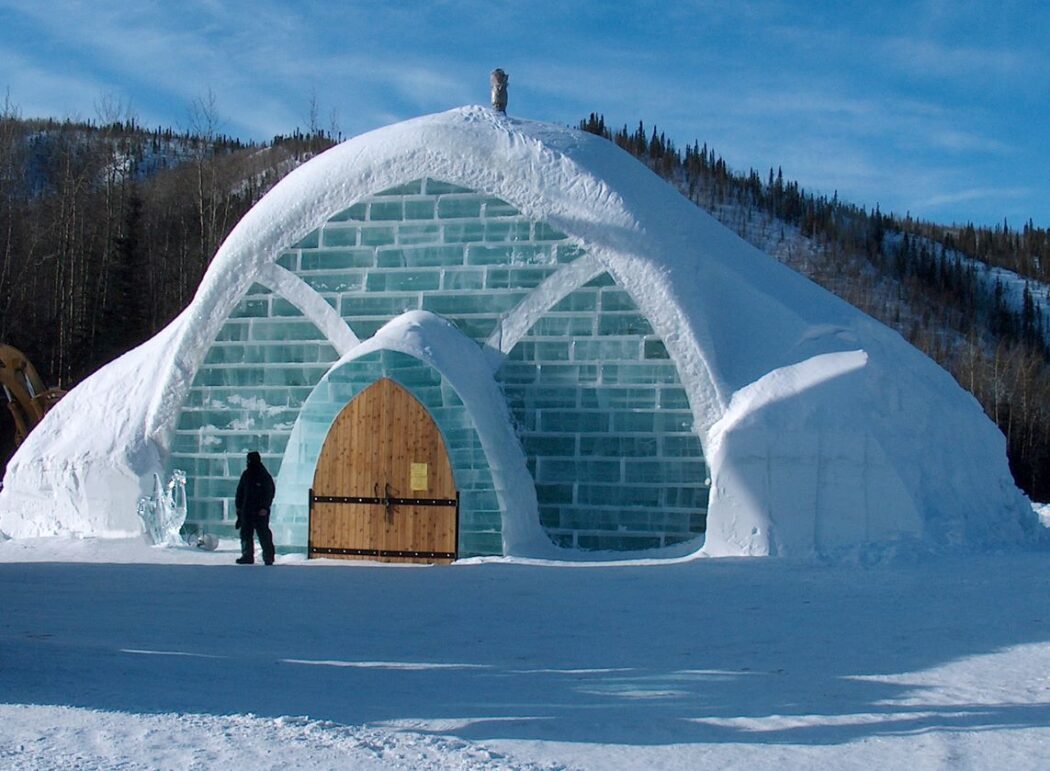 the exterior of a building made out of ice blocks with large wooden doors
