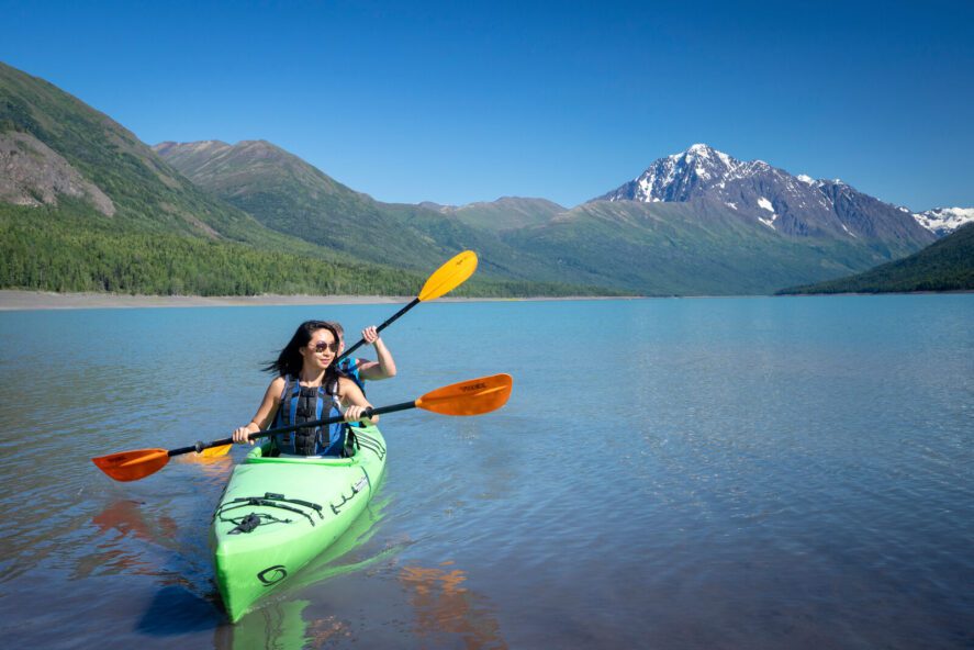 two kayakers in a tandem kayak on a glacial lake in Alaska