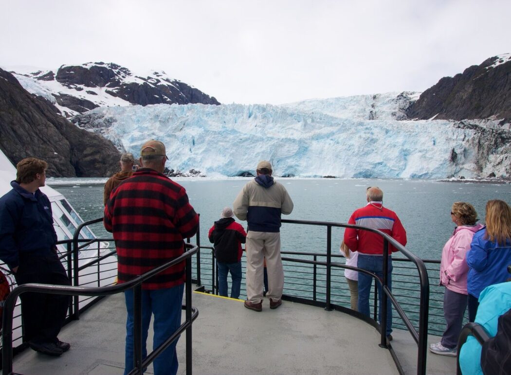 people standing on the deck of a tour boat looking at a tidewater glacier in Kenai Fjords National Park