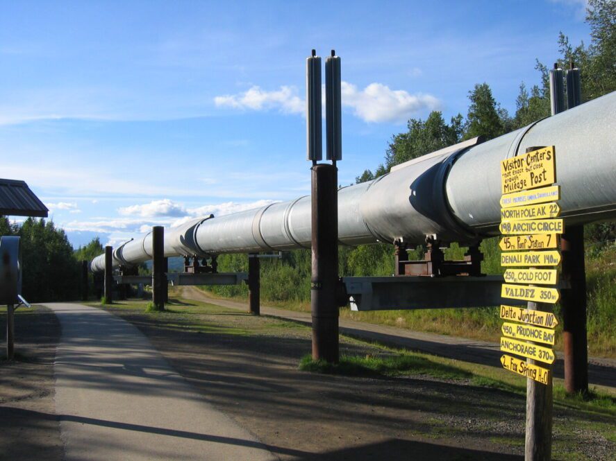the Trans-Alaska Pipeline next to an access path and directional sign