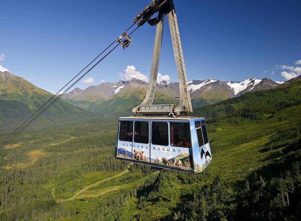 an aerial tram with the words "Alyeska Resort" in a mountainous landscape