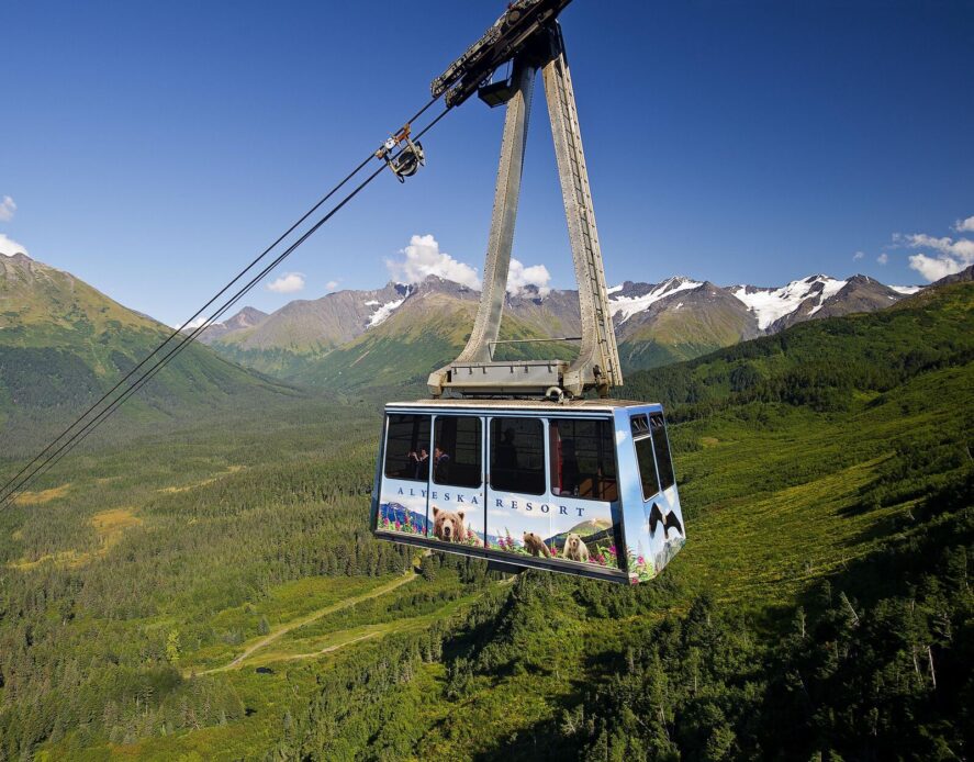 an aerial tram with the words "Alyeska Resort" in a mountainous landscape