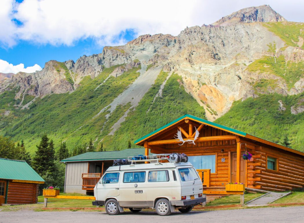 A vehicle parked in front of a log cabin a a lodge on Sheep Mountain in Alaska