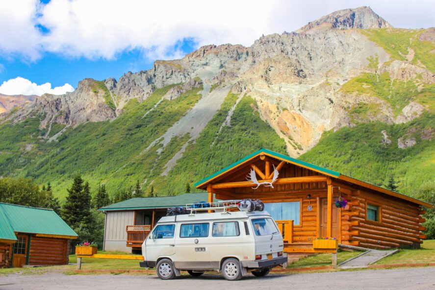 A vehicle parked in front of a log cabin a a lodge on Sheep Mountain in Alaska