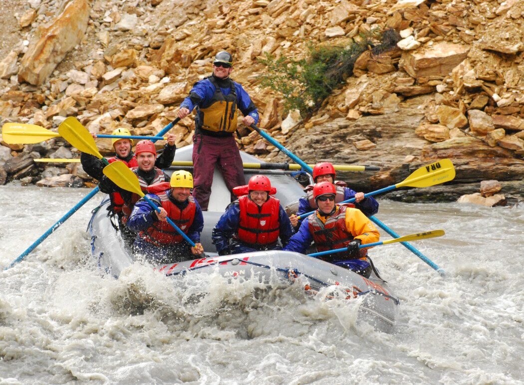 a group of people whitewater rafting in a canyon