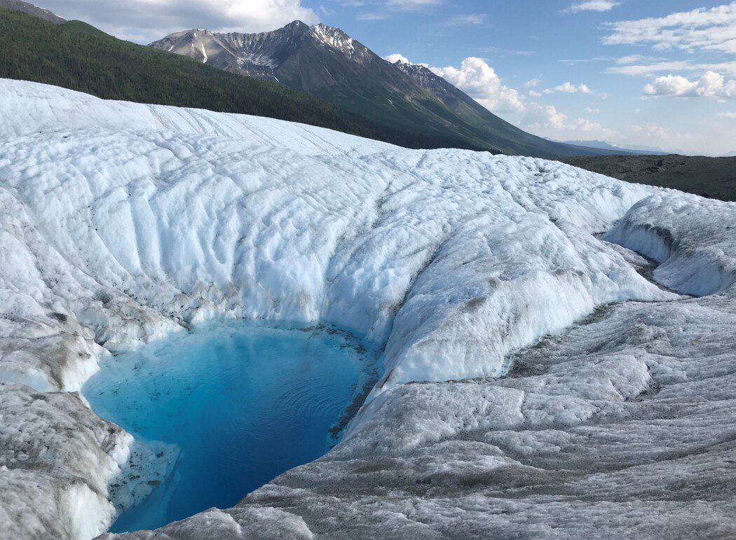 a pool of water atop a glacier