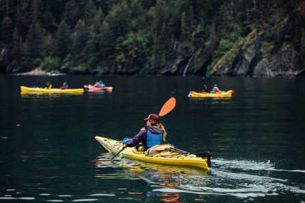 kayakers paddling along the coast of Fox Island in Resurrection Bay, Alaska