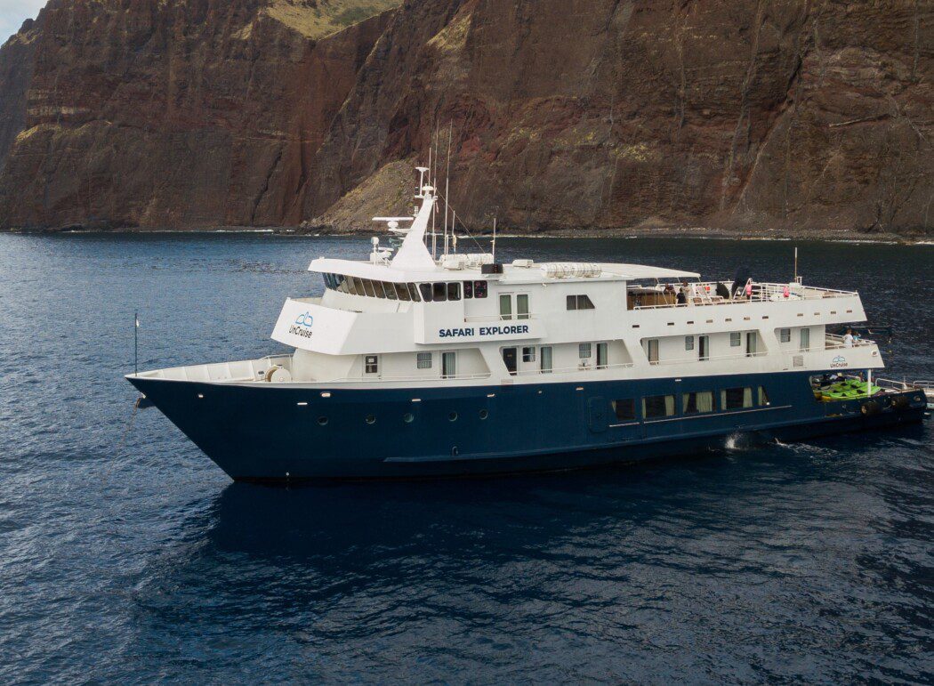 the small cruise ship 'Safari Explorer' near coastal cliffs
