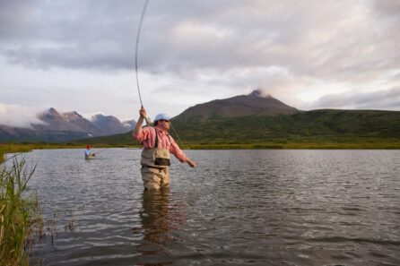a person fly fishing in a lake in Alaska