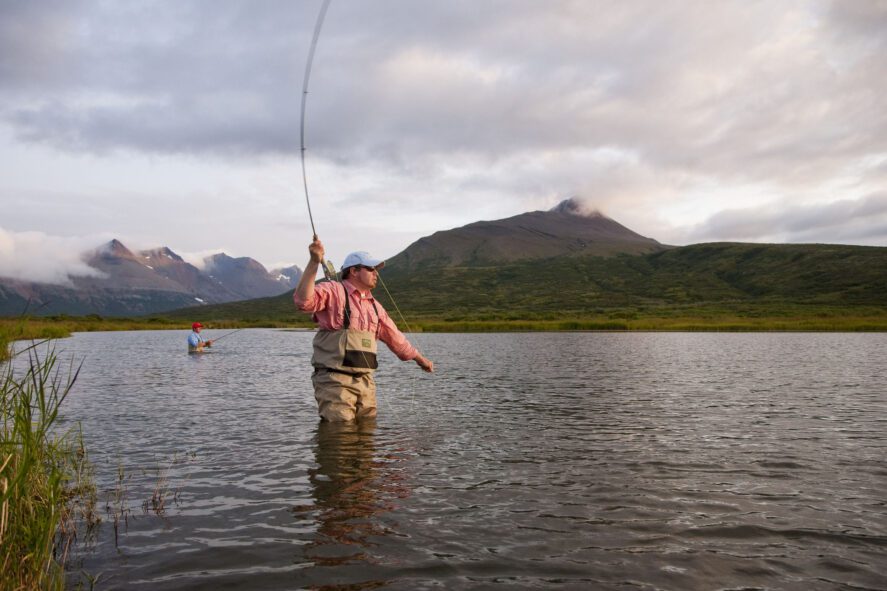 a person fly fishing in a lake in Alaska