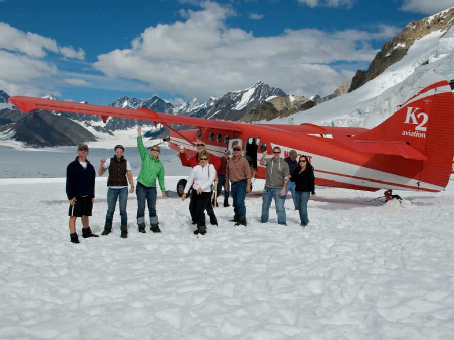 Group in front of K2 Aviation plane on a glacier