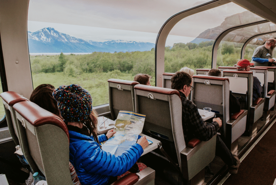 People viewing a map on an Alaska Railroad train